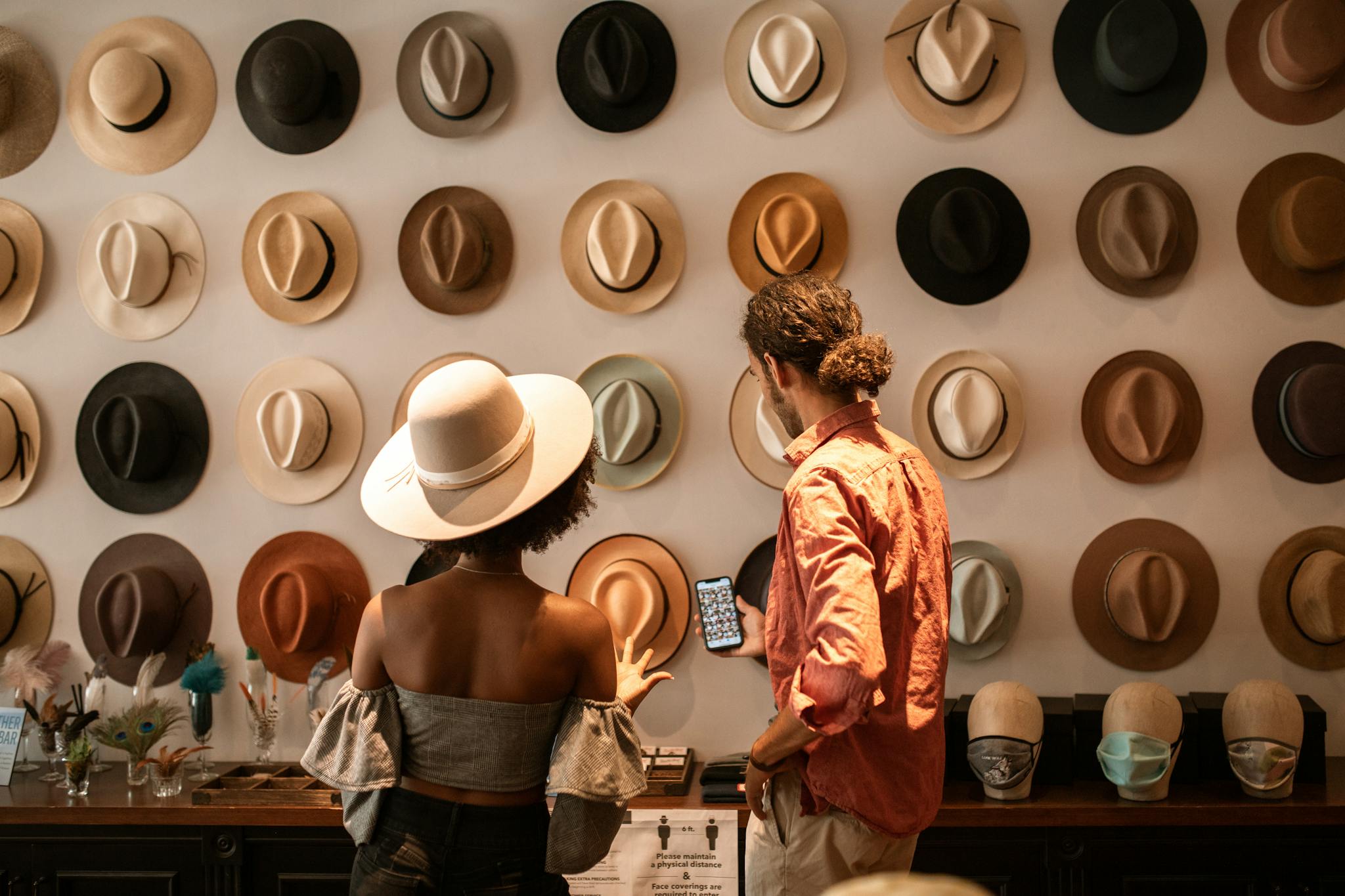 A stylish couple exploring a&nbsp;hat boutique, showcasing diverse headwear.